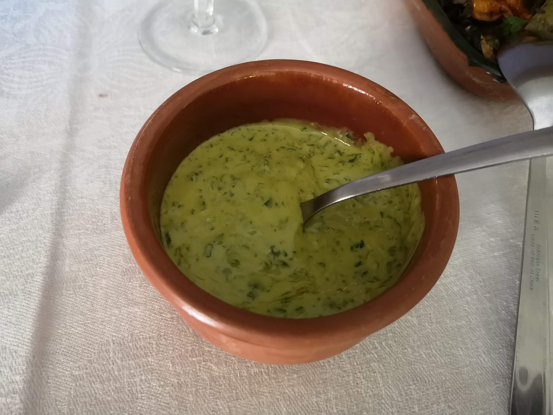 Green pouring mayonnaise with herbs